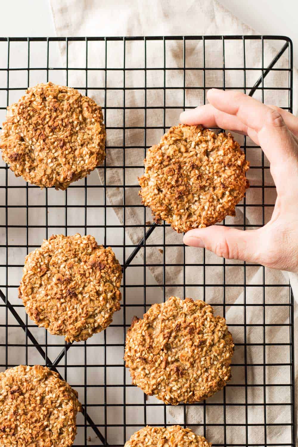 Grabbing a cookie from on a cooling rack.