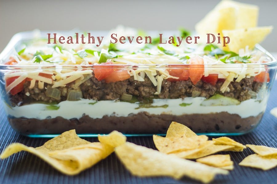 Healthy Seven Layer Dip viewed from the side with tortilla chips.