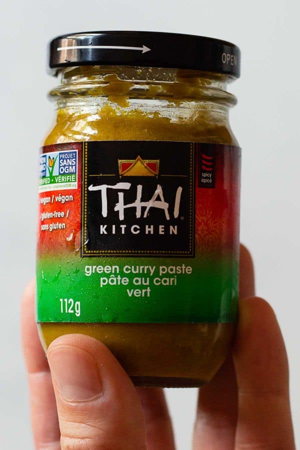 Thai Kitchen brand Thai Green Curry container held in hand.