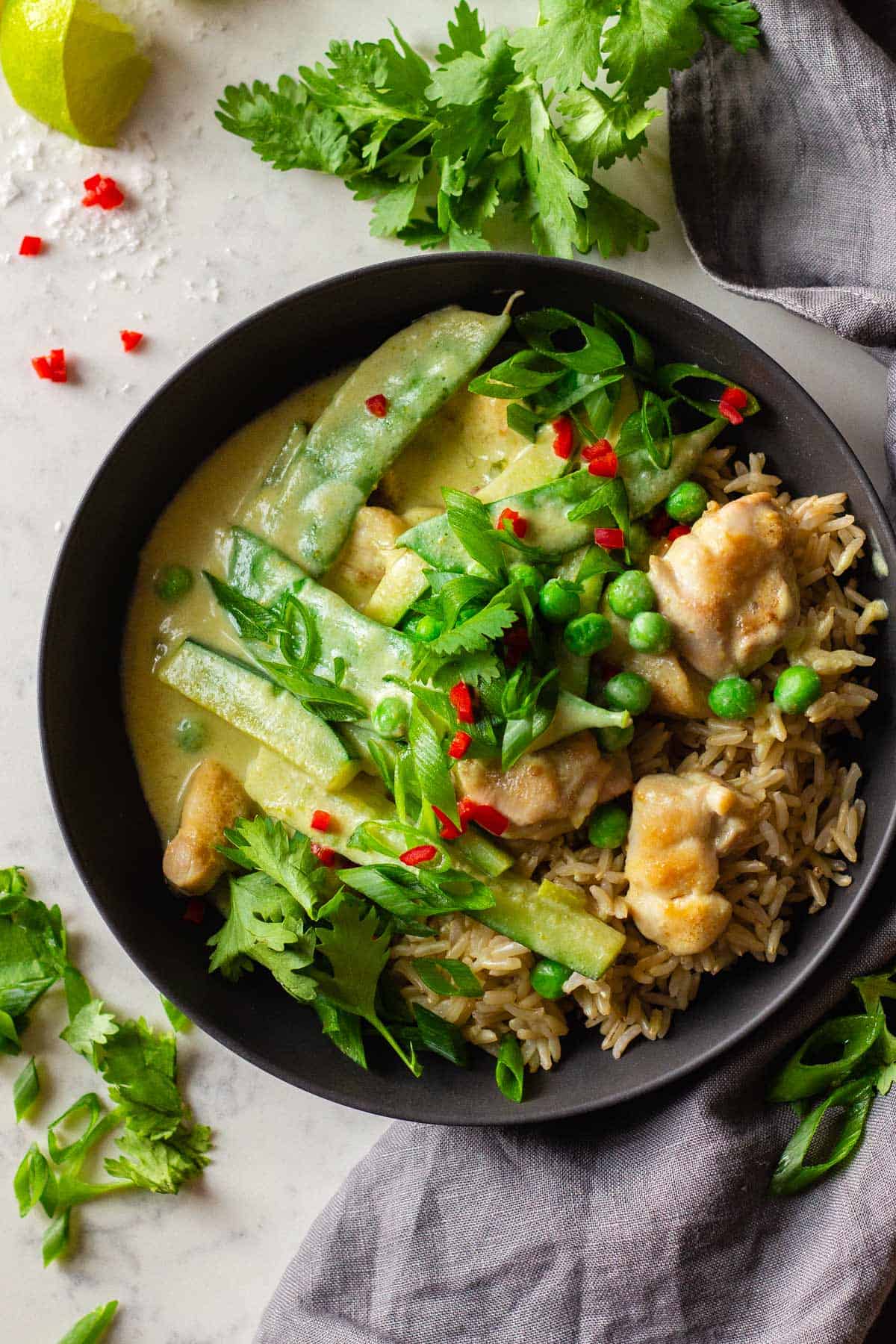 Chicken Thai Green Curry served over brown rice in a grey bowl.