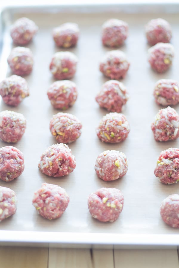 Raw Pistachio Meatballs on a baking pan.