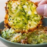 Zucchini cheese crisp being lifted off a plate.