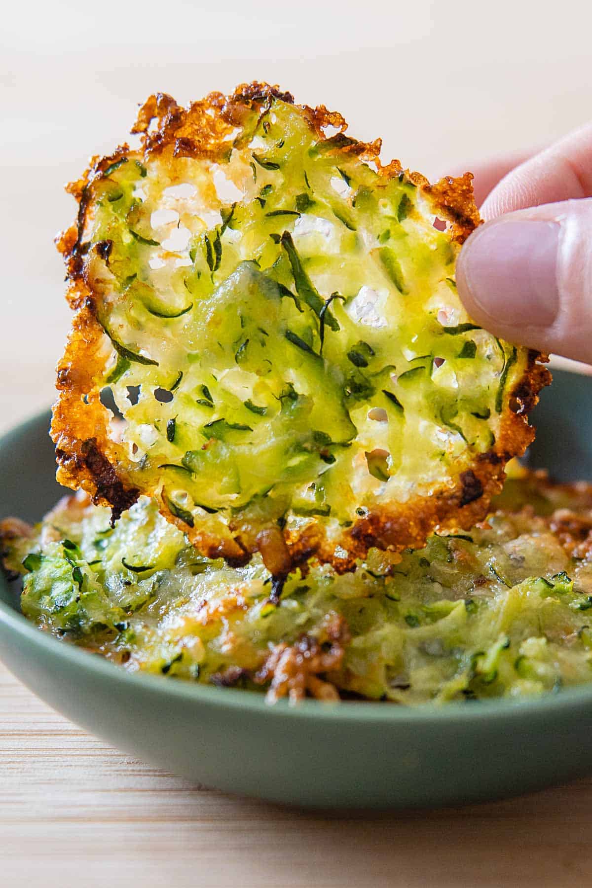 Zucchini cheese crisp being lifted off a plate.