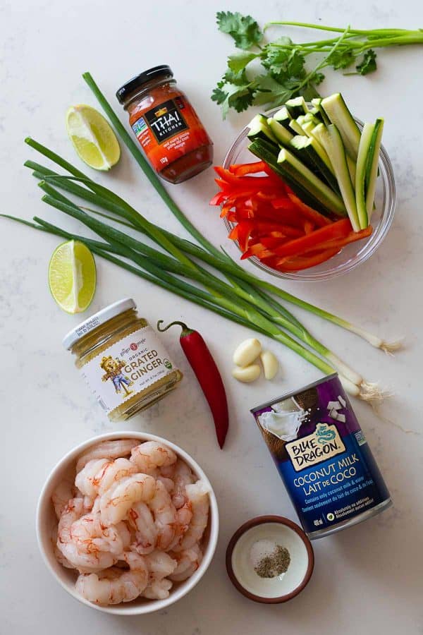 All ingredients for a shrimp curry laid out on a kitchen counter.