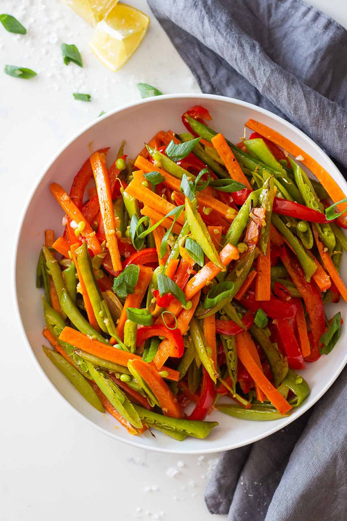 A white plate loaded with sliced roasted vegetables.