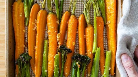 Roasted carrots and broccolini on a baking sheet.