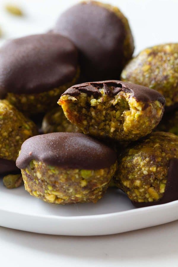 Close-up photo of a biten-into pistachio cookie to show the texture of the cookie. 