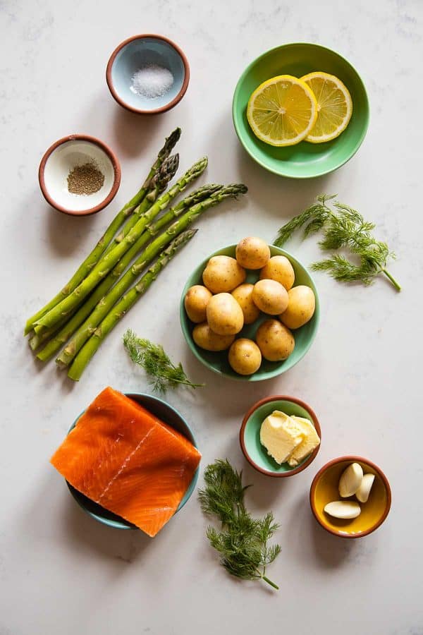 Ingredients for baked salmon pouches with asparagus and potoatoes.