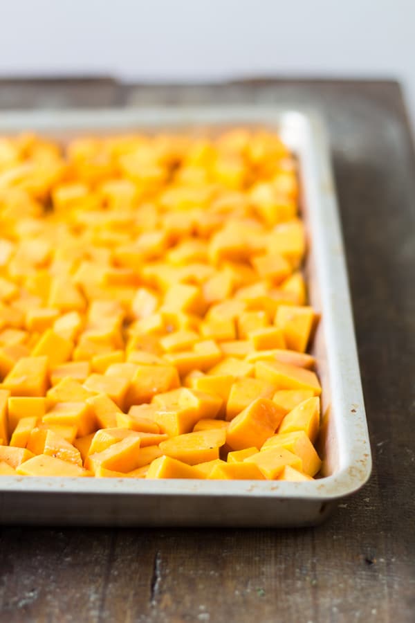 Chopped butternut squash in a baking pan.