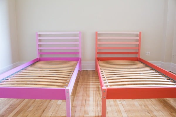 Pink and orange Ikea Tarva Beds side by side in a bedroom.