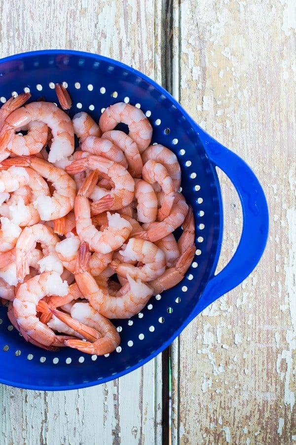 Shrimps in a blue strainer basket.