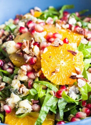 Close up of the best winter salad - Romaine Lettuce, Orange Slices, Chopped Pecans, Blue Cheese and Pomegranate Seeds.