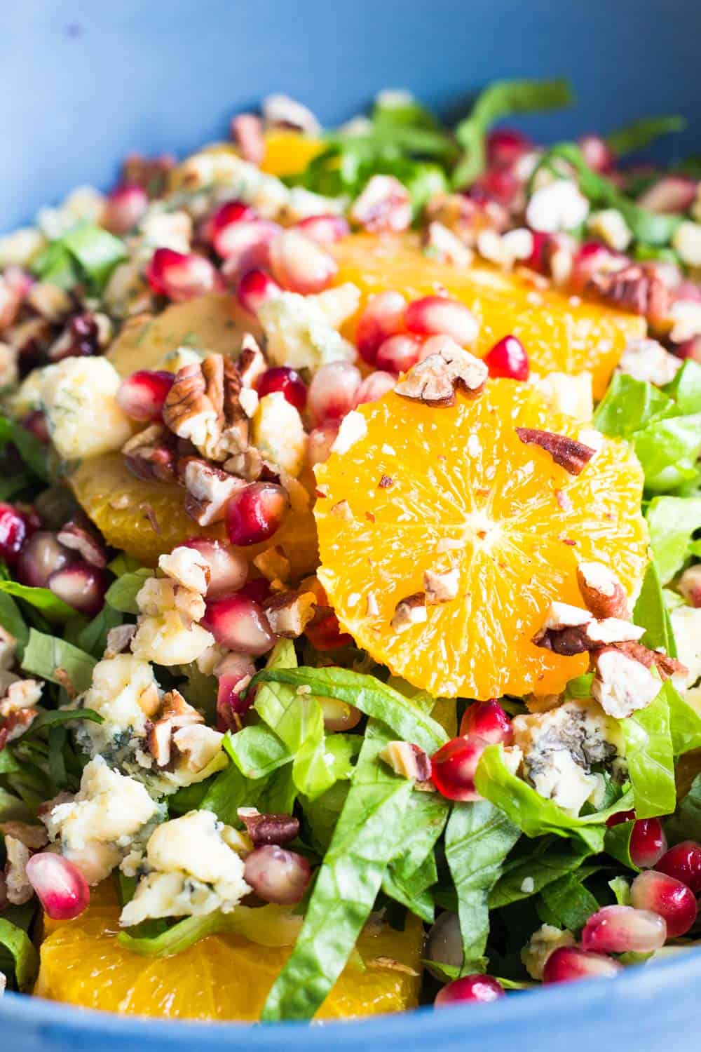 Close up of the best winter salad - Romaine Lettuce, Orange Slices, Chopped Pecans, Blue Cheese and Pomegranate Seeds.