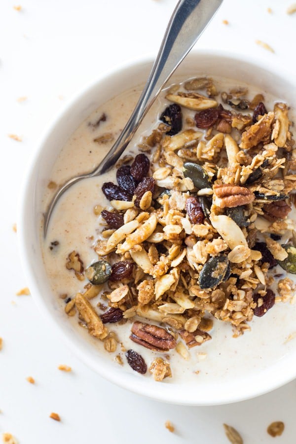 Top view of a bowl of Healthy Homemade Granola with milk and a spoon.