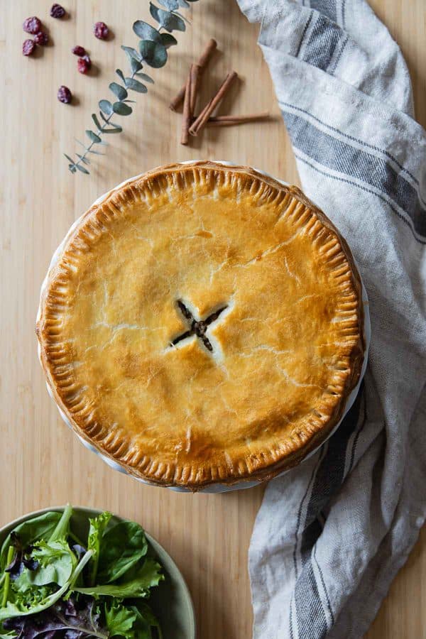 Whole, uncut, Tourtière meat pie on a kitchen counter.