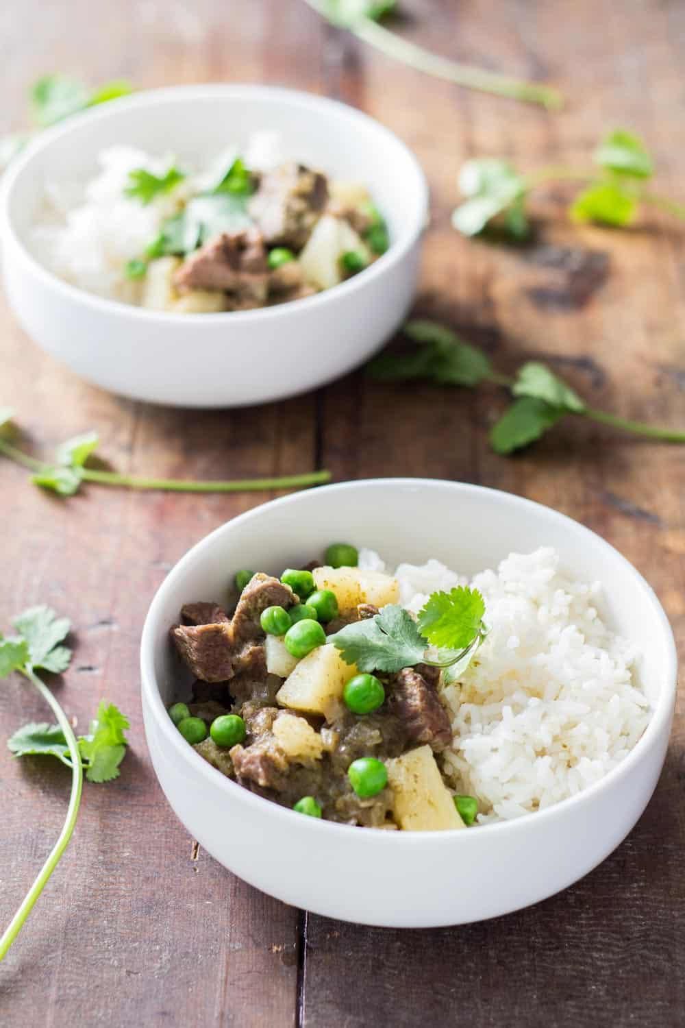 Two bowls of Peruvian Lamb Stew with rice and peas. 