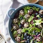 Warm Goat Cheese Salad in blue salad bowl with blueberries