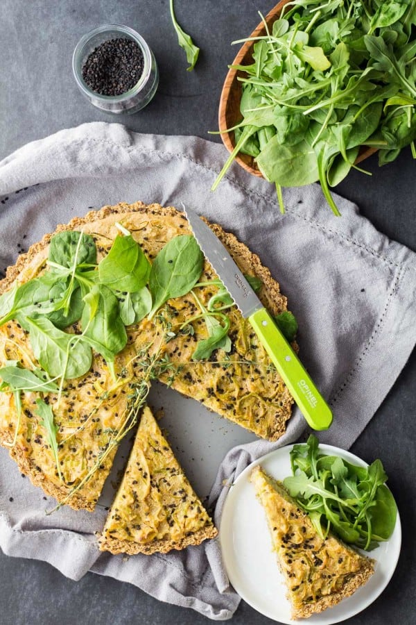 Top view of sliced gluten-free vegan quiche with salad.