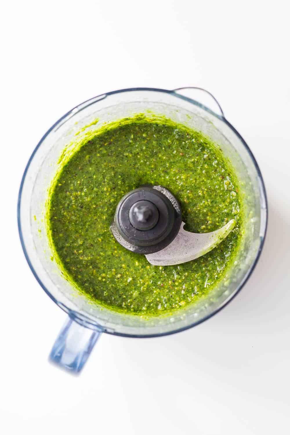 Top view of blended 5-Minute Basil Pistachio Pesto in a food processor.