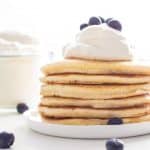 Extra Fluffy Pancakes topped with whipped cream and blueberries.