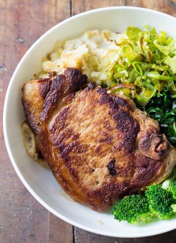 Close up of Perfect Pork Chop with mashed potatoes, celery, chard and broccoli.