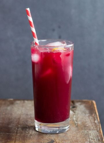Blood orange lemonade in a glass with a paper straw