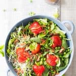 Top view of Strawberry Bacon Spring Salad and a jar of Maple Mustard Balsamic Dressing.