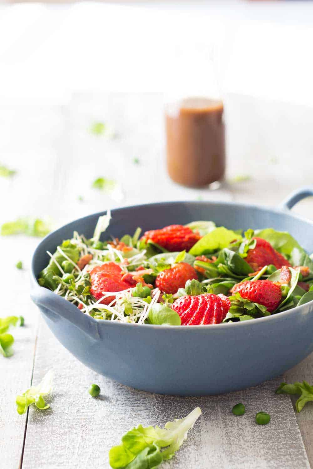 Strawberry Bacon Spring Salad in a blue bowl, and a Maple Mustard Balsamic Dressing.