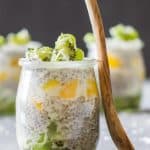 Close up of jar of Tropical Chia Pudding with a wooden spoon.