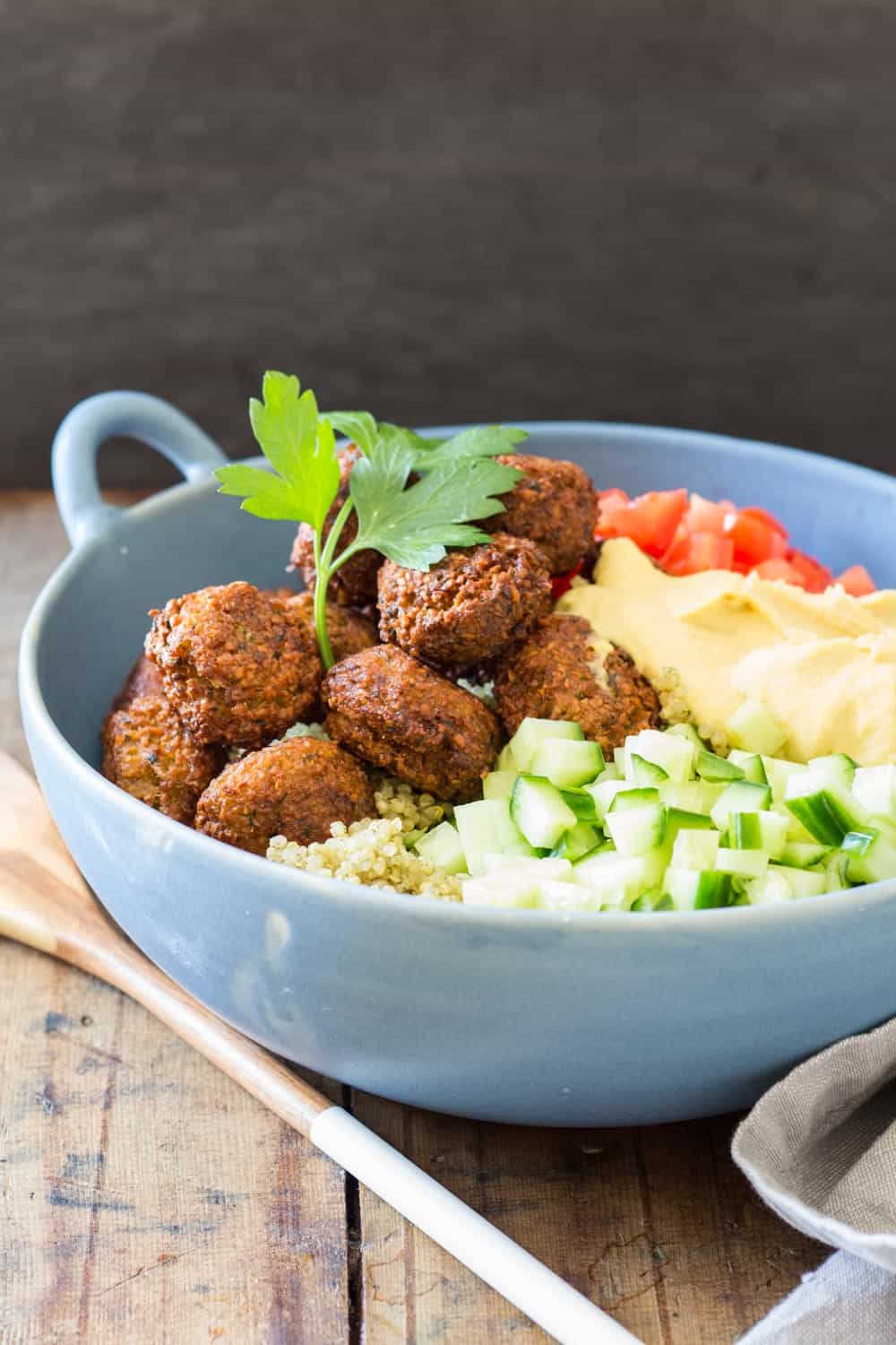 Vegan Quinoa Falafel Bowl in a blue bowl, garnished with fresh parsley.