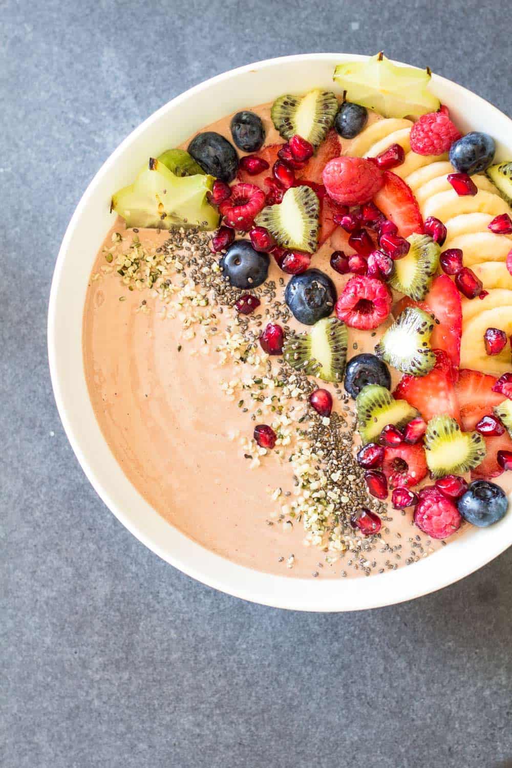 Top view of Chocolate Smoothie Bowl with chopped fresh fruit and seeds.