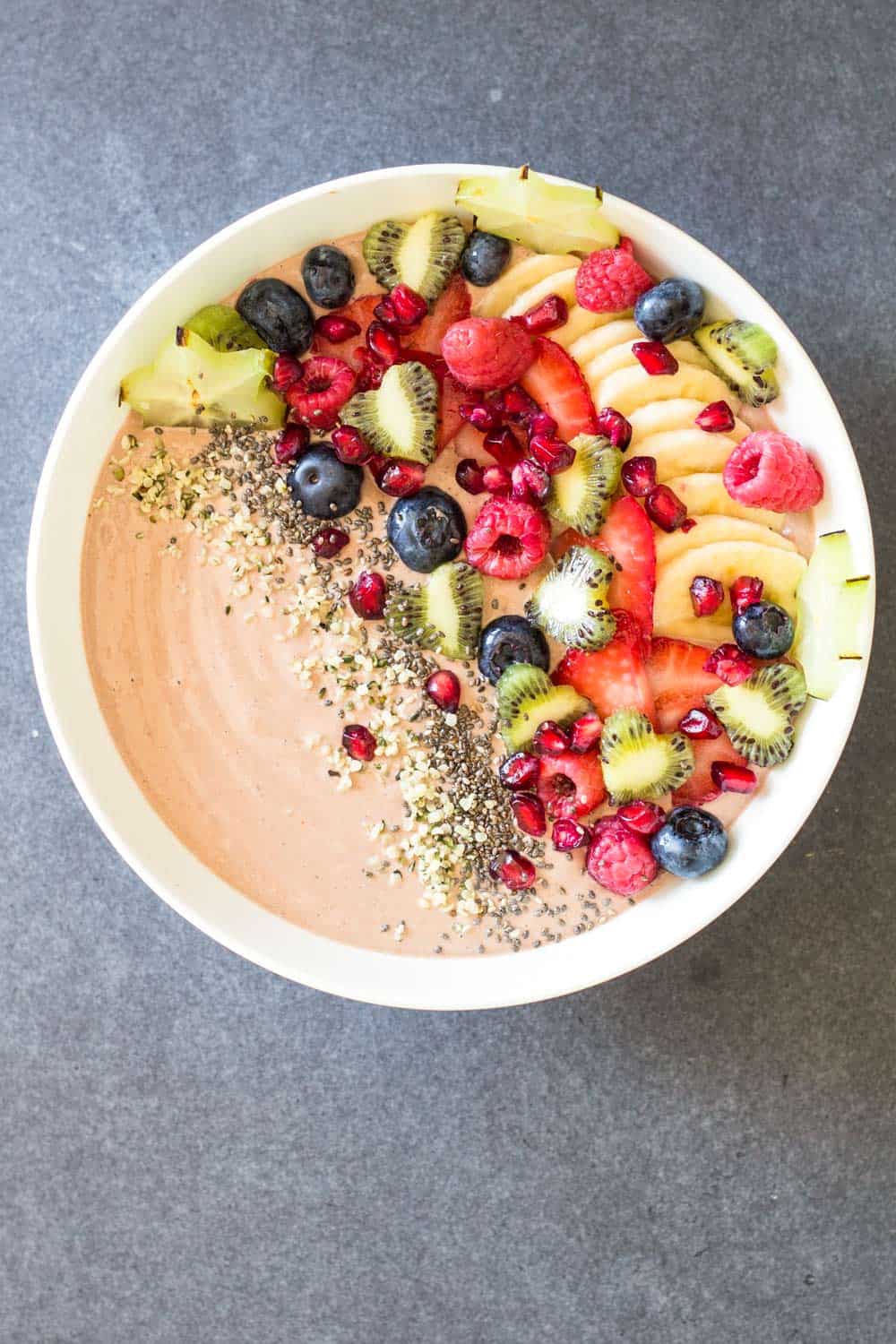 Top view of Chocolate Smoothie Bowl with chopped fresh fruit and seeds.