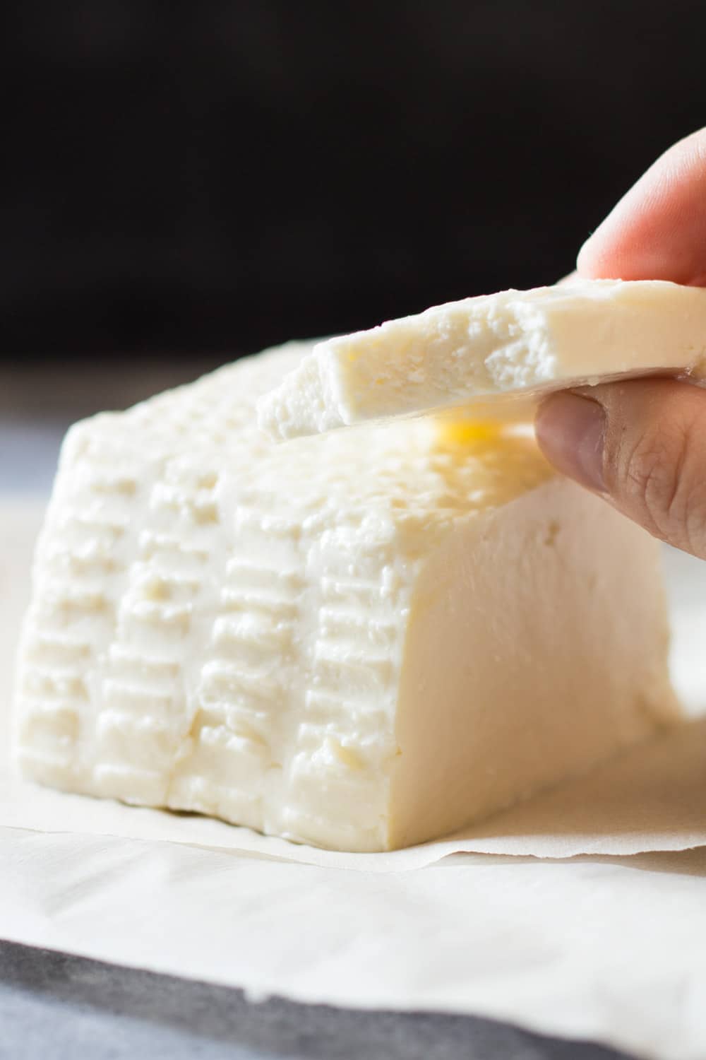 Close up of a slice of queso fresco to show texture.