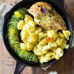 One-Pan Curried Chicken Cauliflower with sliced zucchini in a skillet.