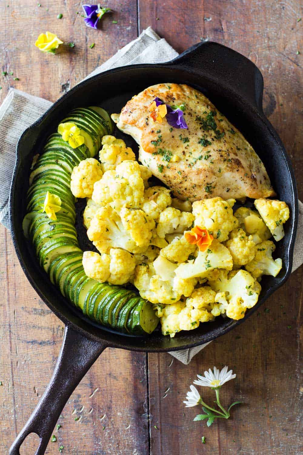 One-Pan Curried Chicken Cauliflower with sliced zucchini in a skillet.