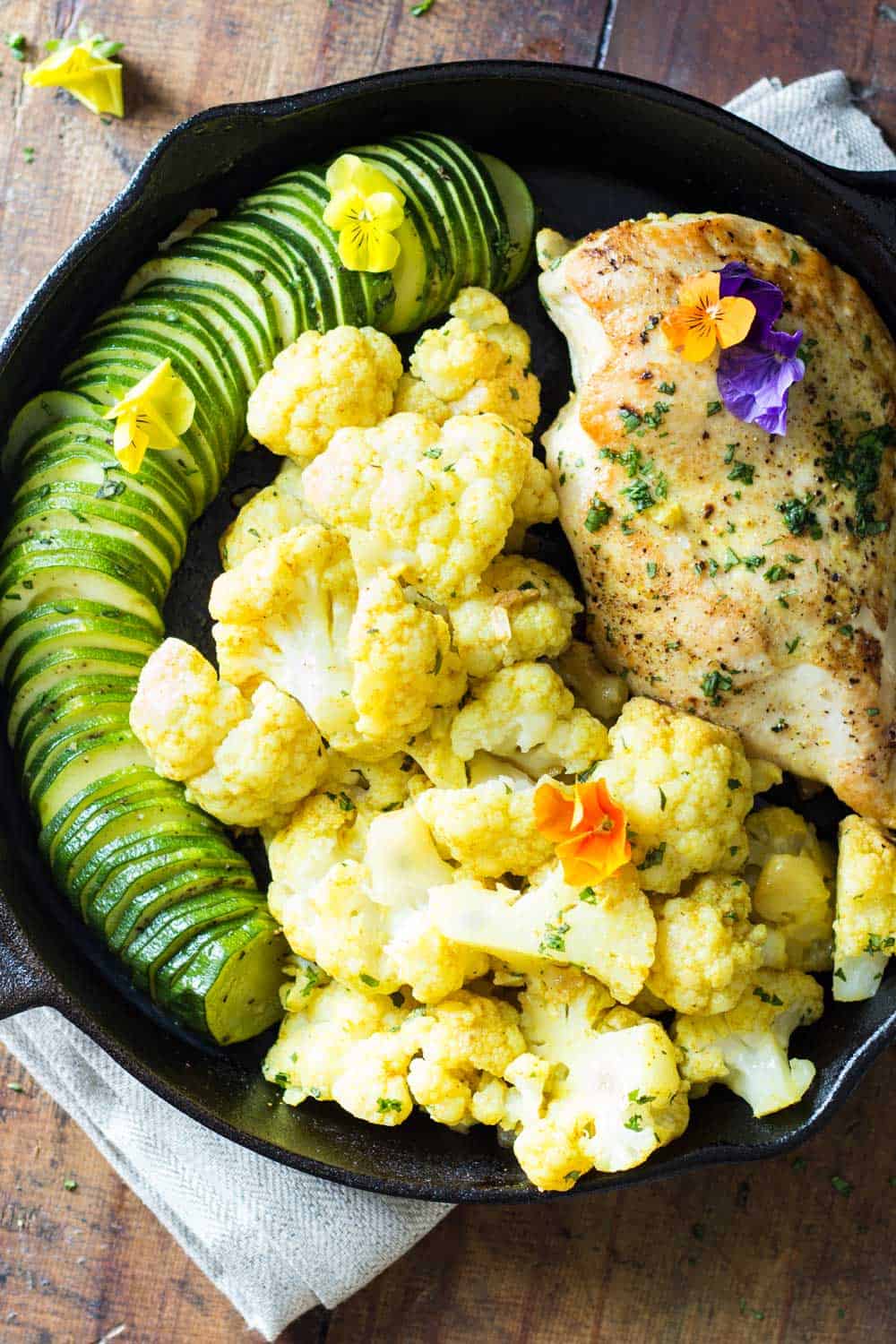 One-Pan Curried Chicken Cauliflower with sliced zucchini in a skillet.