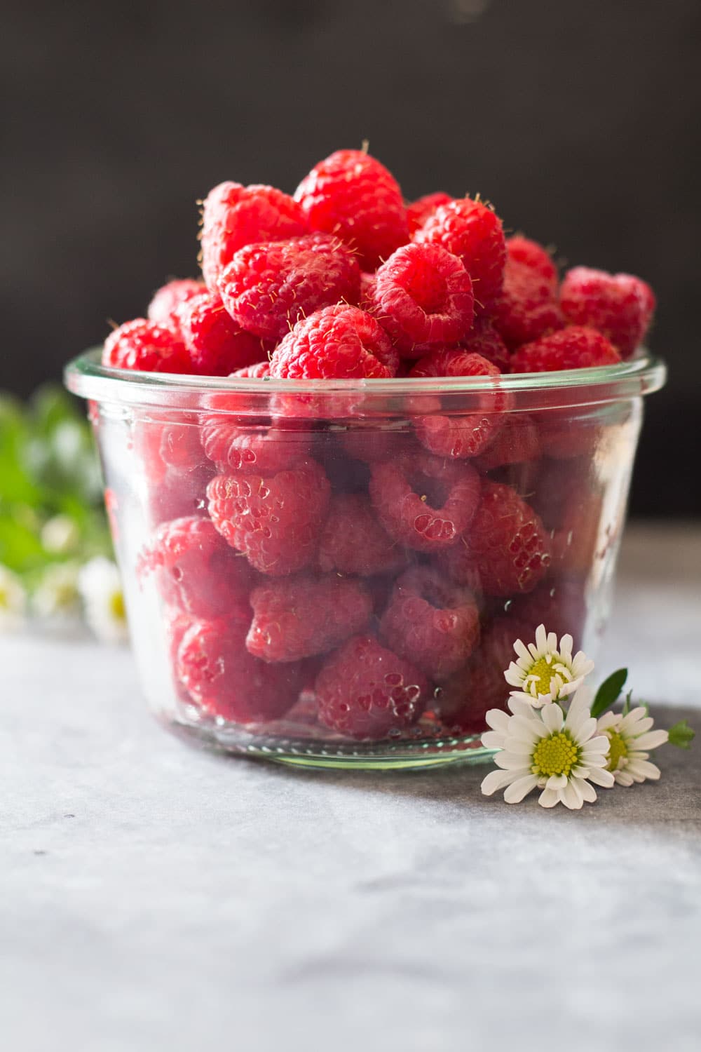 Fresh raspberries in a glass jar.