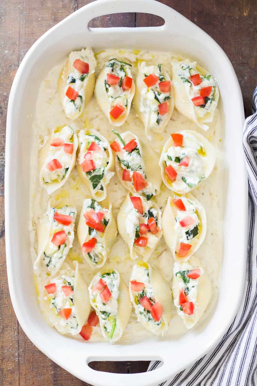 Top view of Spinach Ricotta Stuffed Shells in a white baking dish.