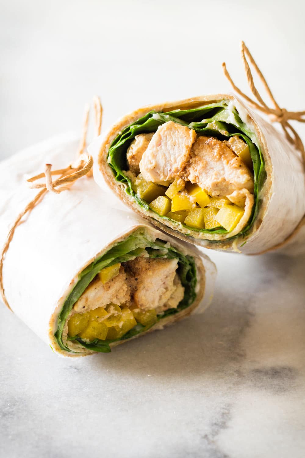 Healthy Chicken Wrap sliced in two, tied with jute twine.