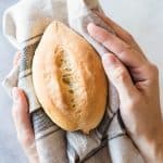 Bolillo on top of kitchen towel held in hand