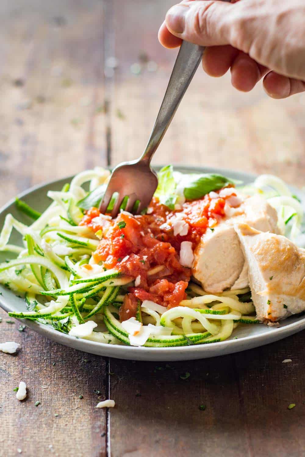 Hand grabbing some Easy Chicken Zoodles with a fork.