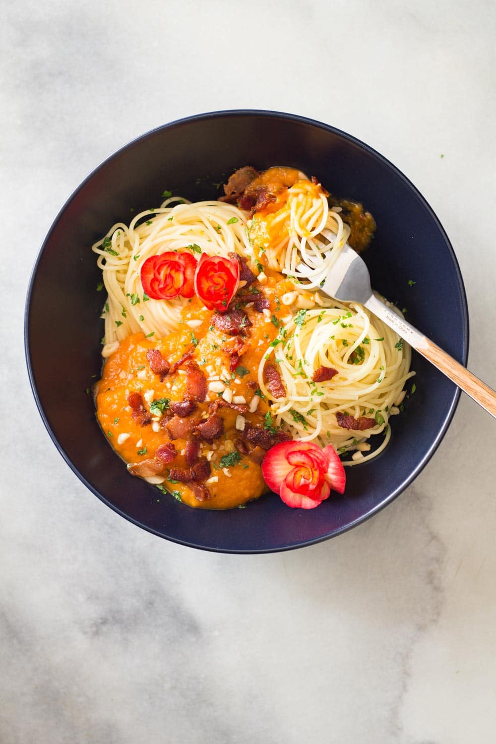 Spaghetti with Butternut Squash Pasta Sauce and Bacon, with a fork, in a black bowl.