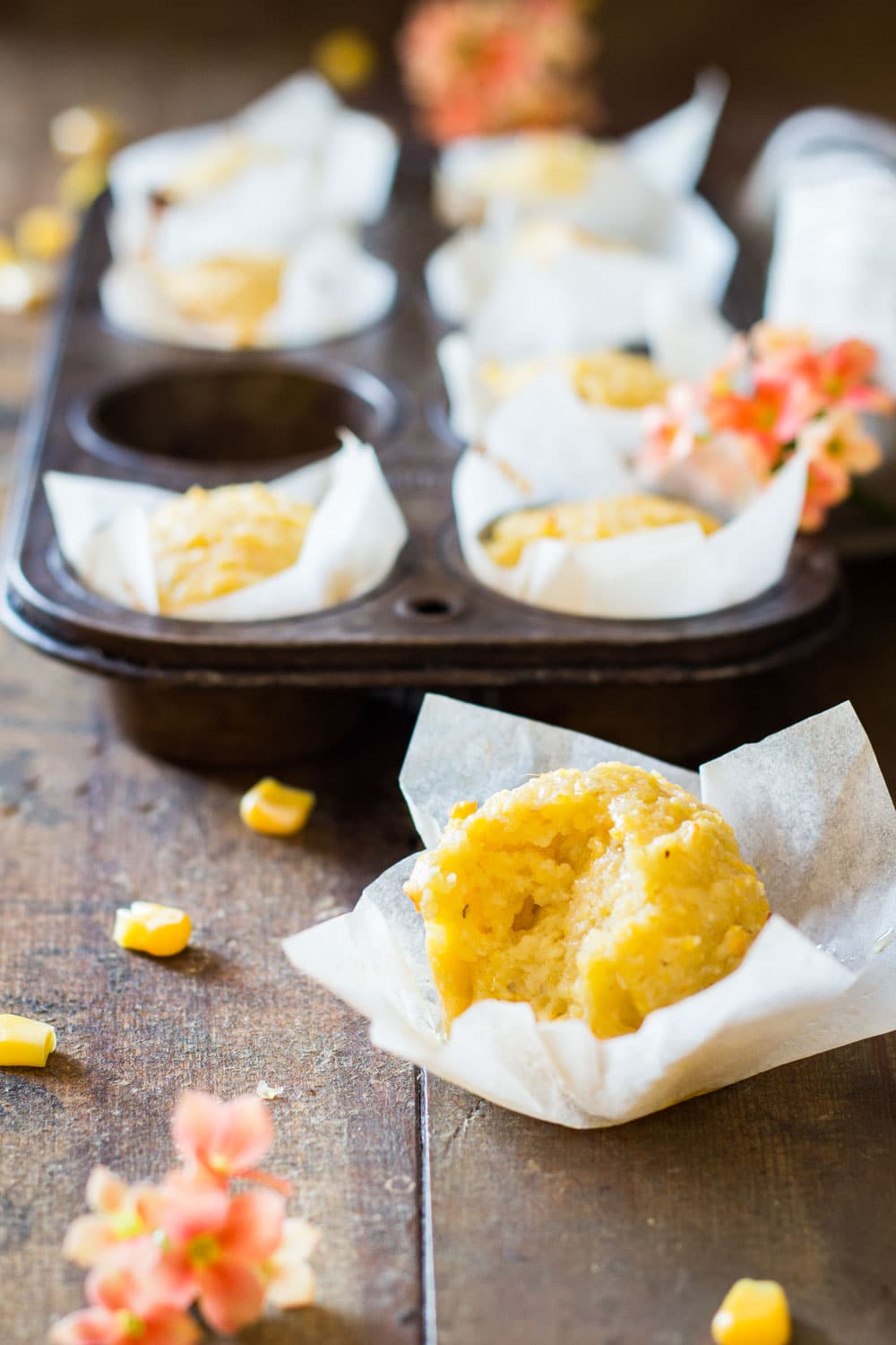 Close up of cornbread muffin with a bite taken off.