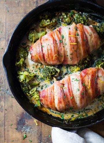 Bacon wrapped chicken breast in a pan with brocooli and creamy suace