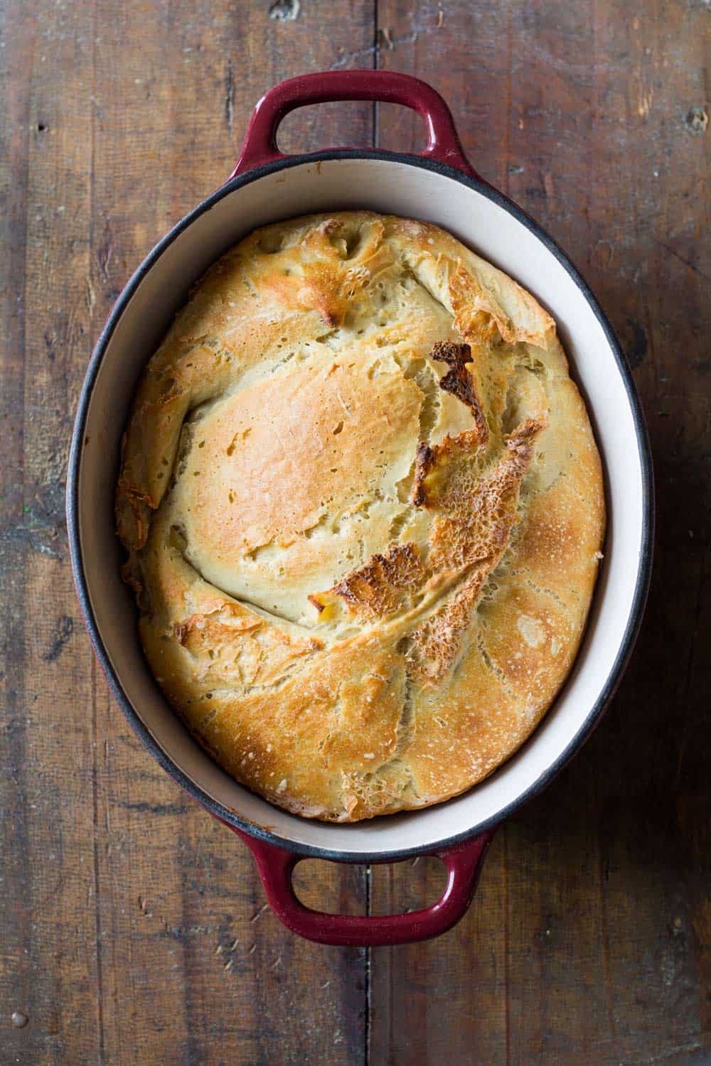 Apple Yeast Bread ready baked in red oval dutch oven.