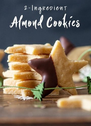 One Almond Flour Cookie leaning agains a stack of Almond Cookies