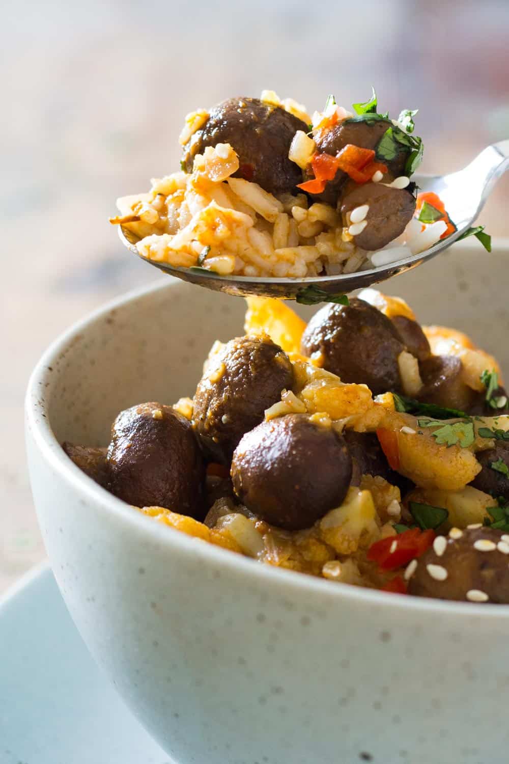 Spoonful of vegan yellow curry to show texture, over bowl of curry. 