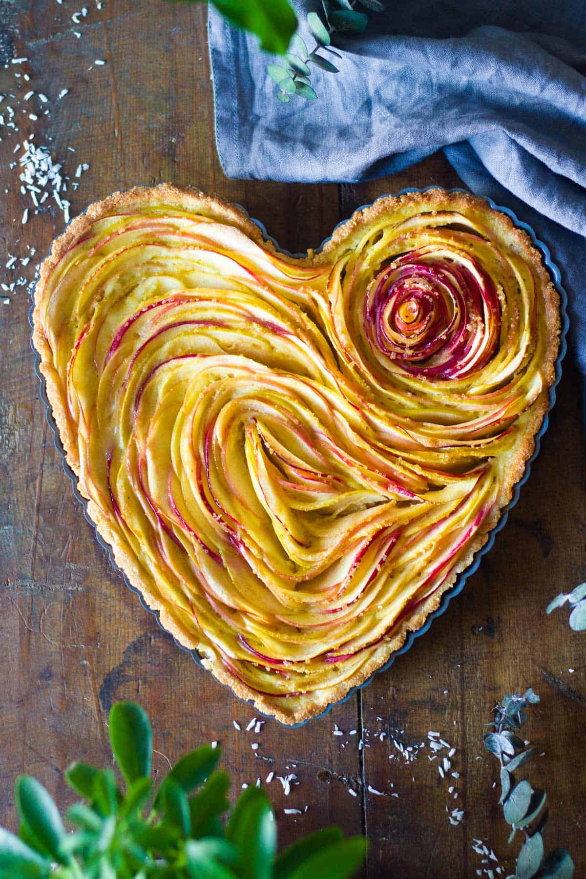 Baked apple tart in heart-shaped tart pan.