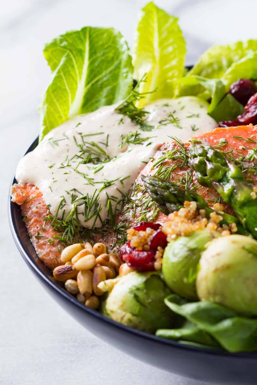 aked Sockeye Salmon topped with creamy caesar dressing and served with lettuce leaves, dried cranberries, pine nuts, asparagus, avocado balls and quinoa.