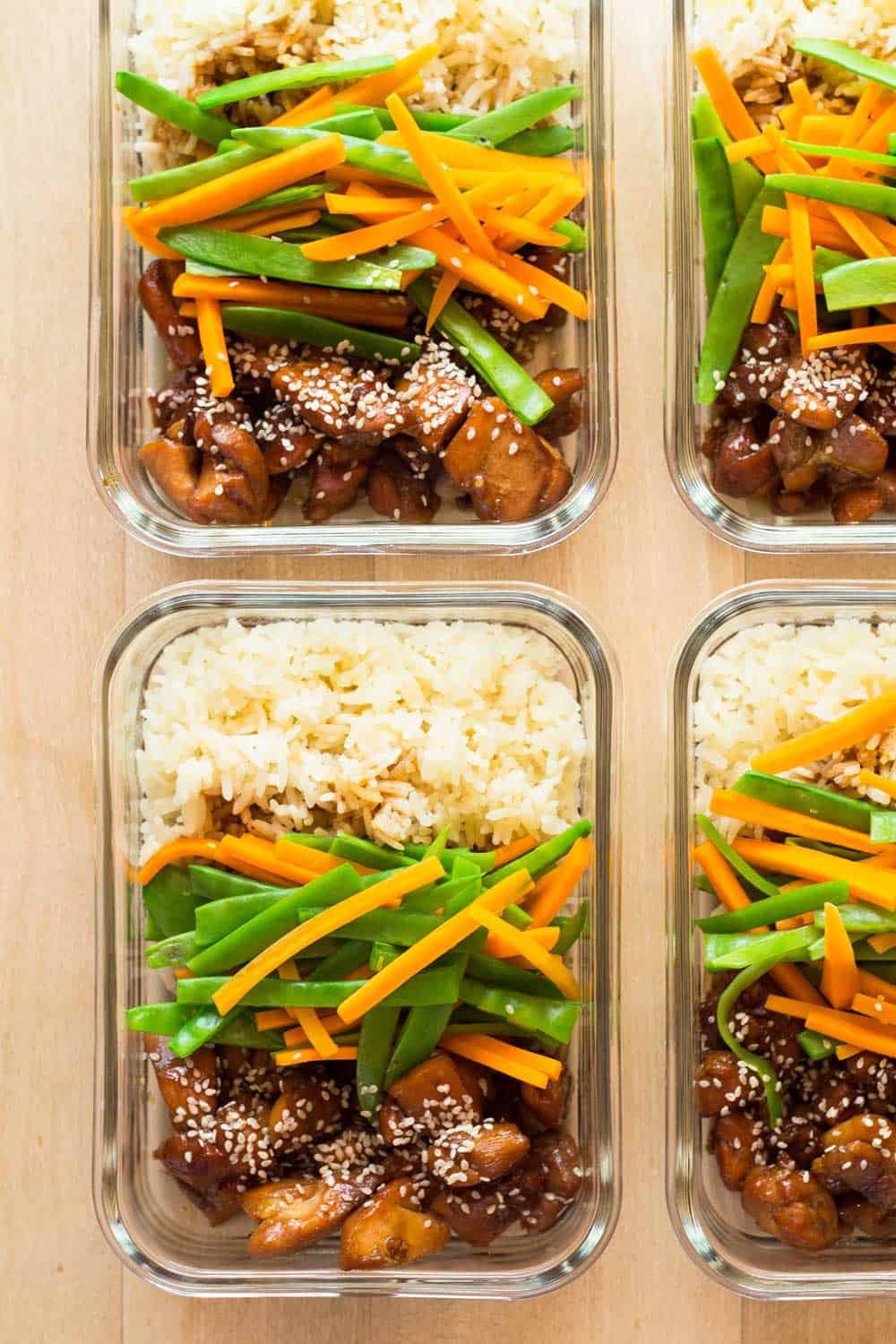 Four meal prep bowls with vietnamese chicken, veggies and white rice